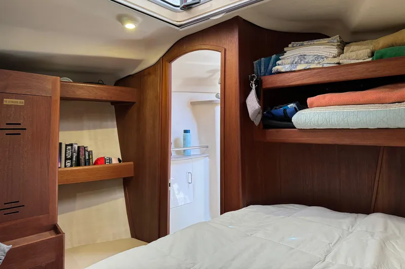 Orion Yacht Photos Pics Cozy cabin interior of 2002 Hunter 410 sailboat with wooden shelves and bedding.
