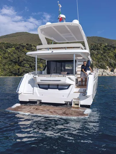 Absolute 50 Fly Yacht Photos Pics 2025 Absolute 50 Fly yacht on water, scenic backdrop, person onboard.