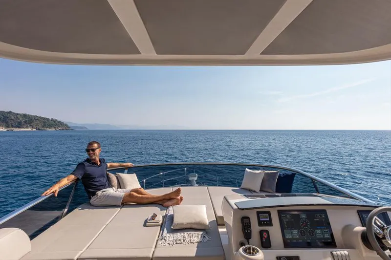 Absolute 50 Fly Yacht Photos Pics Man relaxing on 2025 Absolute 50 Fly yacht deck, overlooking serene ocean view.