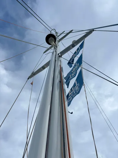  Yacht Photos Pics Sailboat mast of 2003 Oyster 56 with blue flags against cloudy sky.
