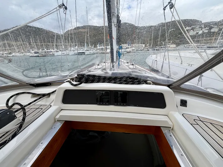  Yacht Photos Pics Cockpit view of 2003 Oyster 56 sailboat in marina, surrounded by hills and yachts.