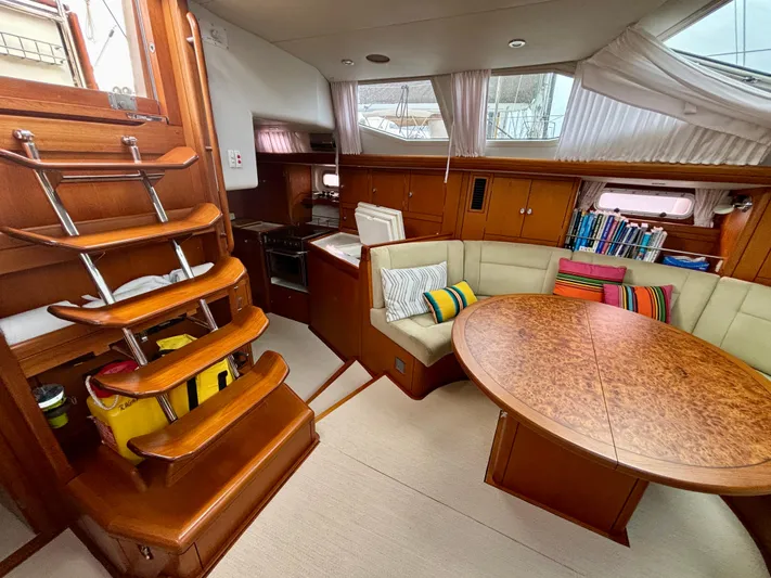  Yacht Photos Pics Luxurious interior of 2003 Oyster 56 yacht with wooden finishes and cozy seating area.