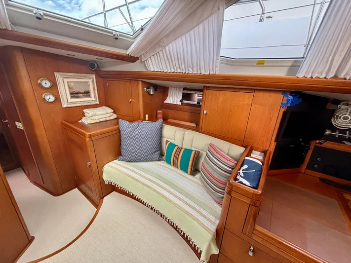  Yacht Photos Pics Luxurious interior of a 2003 Oyster 56 yacht with cozy seating and elegant wood finish.