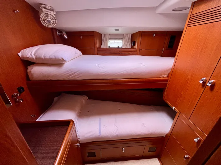  Yacht Photos Pics Cozy cabin with wooden interior and bunk beds on a 2003 Oyster 56 yacht.