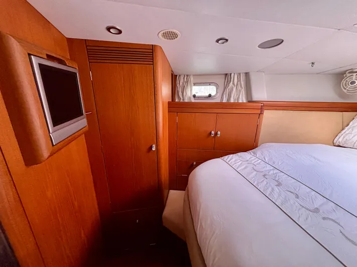  Yacht Photos Pics Luxurious cabin interior of a 2003 Oyster 56 yacht with wood paneling and a mounted TV.