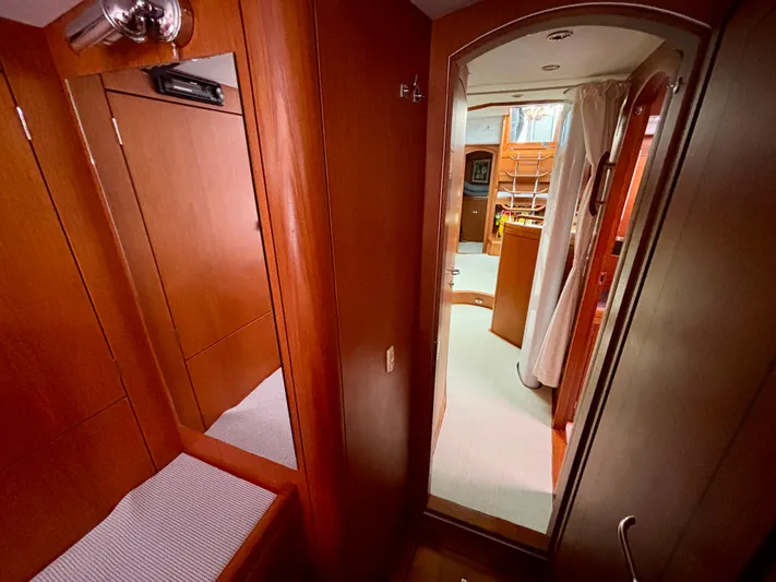  Yacht Photos Pics Interior of 2003 Oyster 56 yacht, featuring wooden cabinetry and cozy passageway.