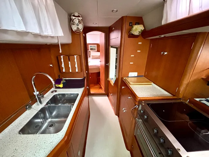  Yacht Photos Pics Interior of 2003 Oyster 56 yacht kitchen with wooden cabinetry and modern appliances.