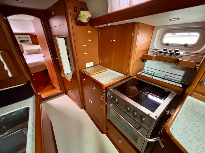  Yacht Photos Pics Galley kitchen in 2003 Oyster 56 yacht with wood cabinetry and modern appliances.