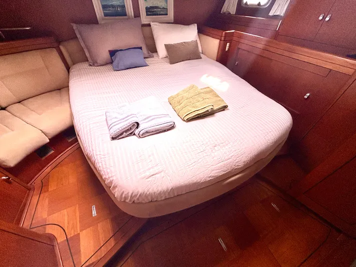  Yacht Photos Pics Luxurious cabin interior of 2003 Oyster 56 yacht with cozy bed and elegant wood finish.