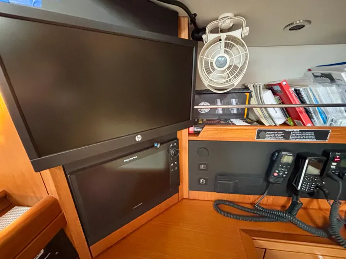  Yacht Photos Pics Navigation station with monitors, fan, and communication devices on a 2003 Oyster 56 yacht.