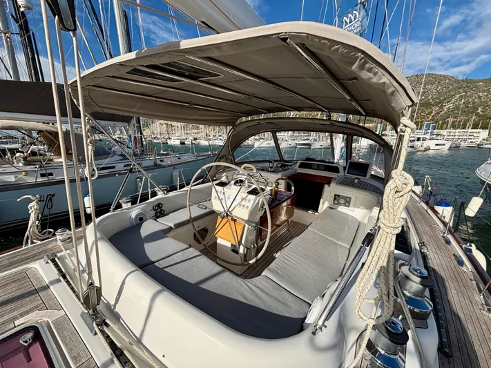  Yacht Photos Pics 2003 Oyster 56 yacht cockpit with steering wheel, docked in marina under clear blue sky.