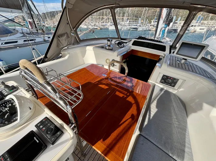  Yacht Photos Pics Cockpit of 2003 Oyster 56 yacht with polished wood table and navigation equipment.