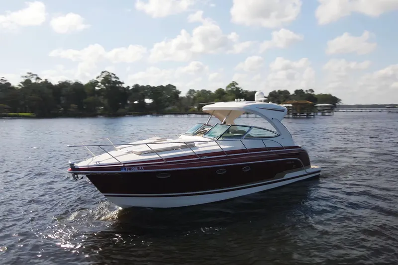 Let Me Liv! Yacht Photos Pics 2015 Formula 34 Performance Cruiser on a serene lake under a partly cloudy sky.