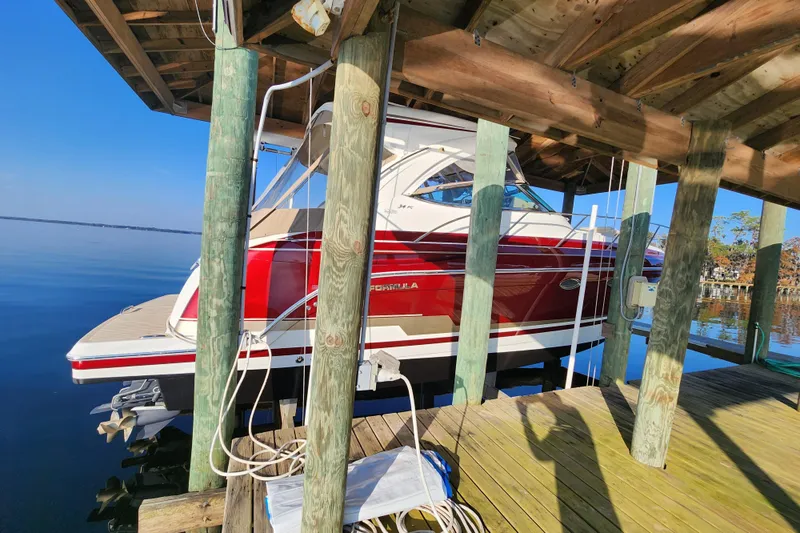 Let Me Liv! Yacht Photos Pics 2015 Formula 34 Performance Cruiser docked under wooden shelter on calm water.