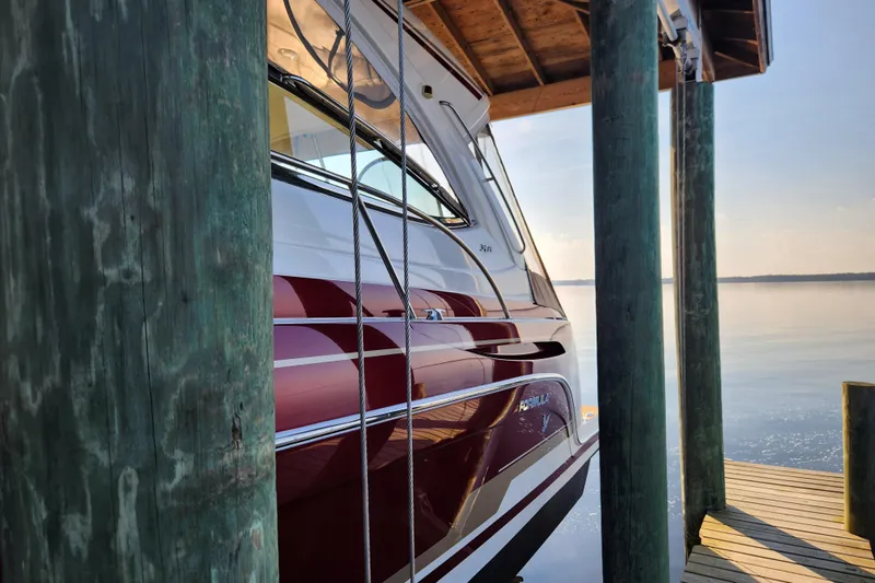 Let Me Liv! Yacht Photos Pics 2015 Formula 34 Performance Cruiser docked by wooden posts on a serene lake.