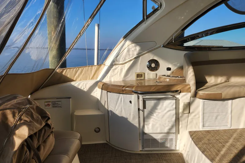 Let Me Liv! Yacht Photos Pics Interior of 2015 Formula 34 Performance Cruiser with seating and kitchenette, overlooking water.