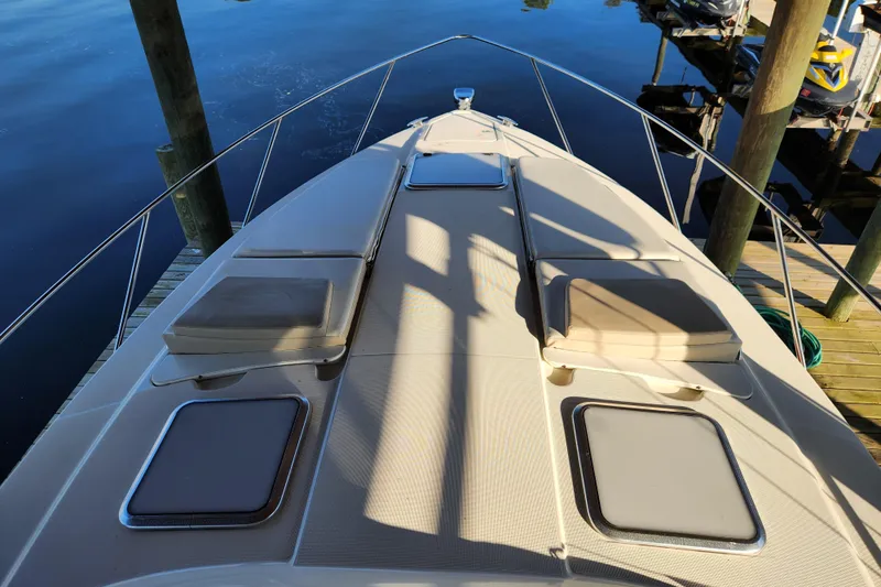 Let Me Liv! Yacht Photos Pics 2015 Formula 34 Performance Cruiser deck with sun pads and hatches, docked by calm water.