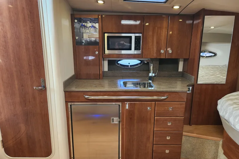 Let Me Liv! Yacht Photos Pics 2015 Formula 34 Performance Cruiser interior with kitchenette, featuring wood cabinetry and modern appliances.