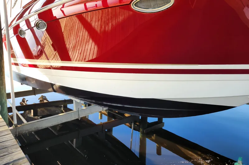 Let Me Liv! Yacht Photos Pics Red 2015 Formula 34 Performance Cruiser on boat lift, reflecting in calm water.