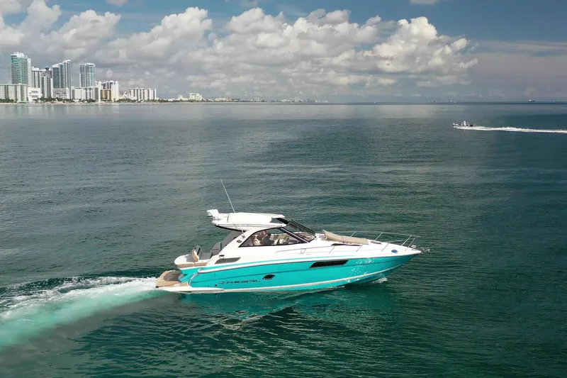  Yacht Photos Pics 2018 Regal 35 Sport Coupe cruising on ocean near city skyline.