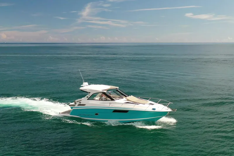  Yacht Photos Pics 2018 Regal 35 Sport Coupe cruising on open sea under clear blue sky.