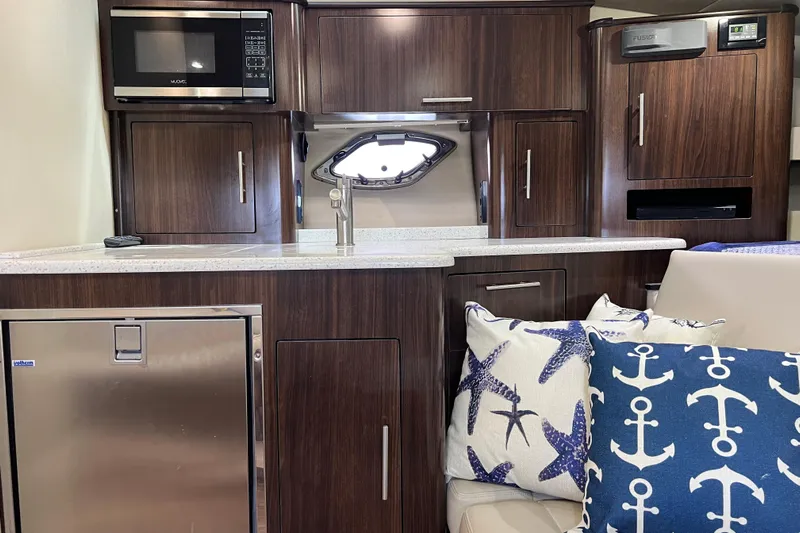  Yacht Photos Pics Interior of a 2018 Regal 35 Sport Coupe with modern kitchen and nautical-themed pillows.