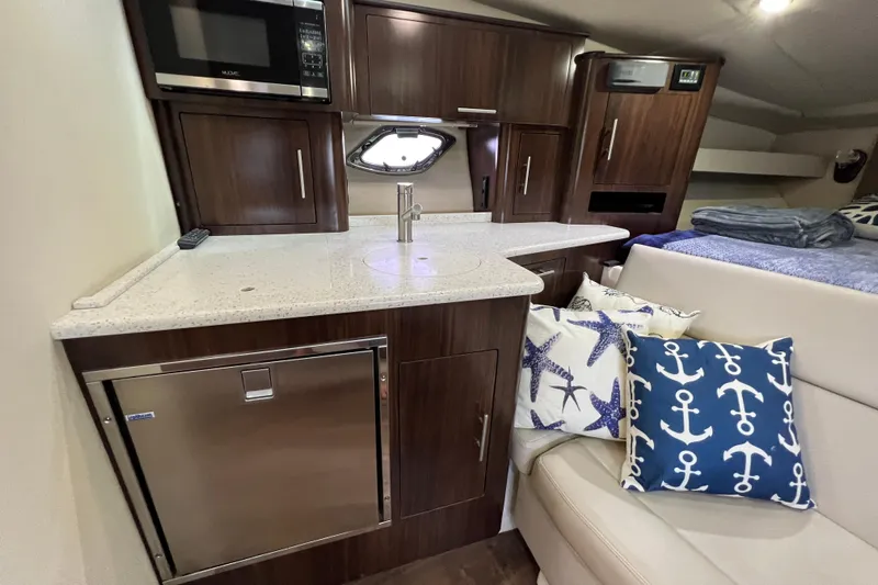  Yacht Photos Pics 2018 Regal 35 Sport Coupe interior with kitchenette, nautical-themed pillows, and modern cabinetry.