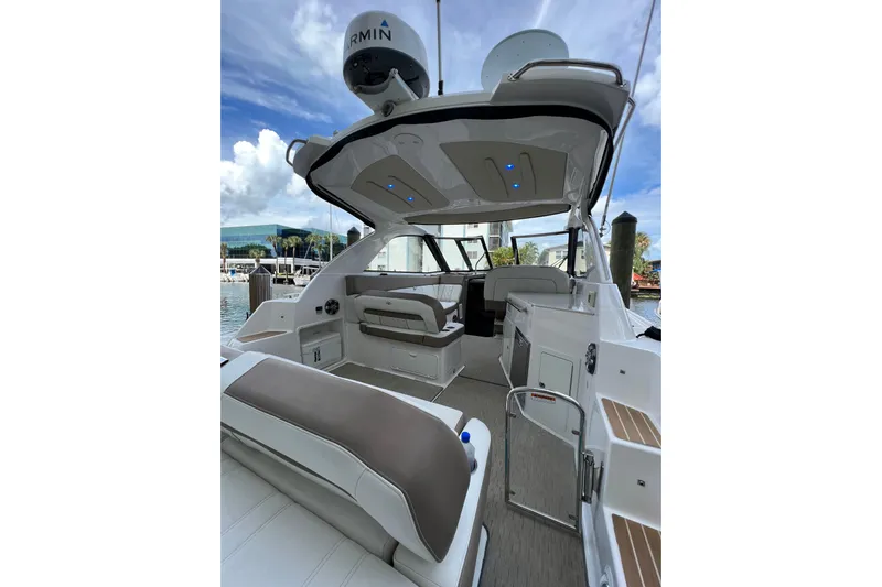  Yacht Photos Pics 2018 Regal 35 Sport Coupe interior with seating, docked at marina under blue sky.
