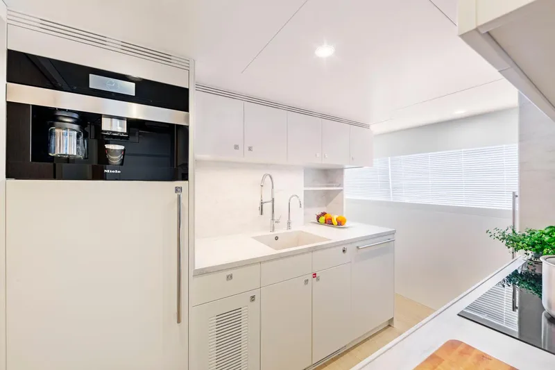 Helga Yacht Photos Pics Modern kitchen interior in 2021 Van der Valk RAISED PILOTHOUSE yacht, featuring sleek white cabinetry.