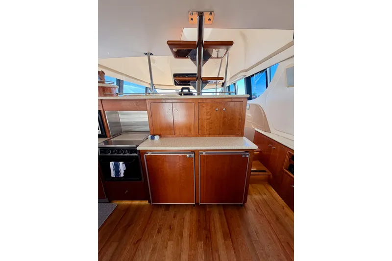 Le Reve Yacht Photos Pics Interior of 1999 Carver 530 Voyager Pilothouse with wooden cabinetry and modern appliances.