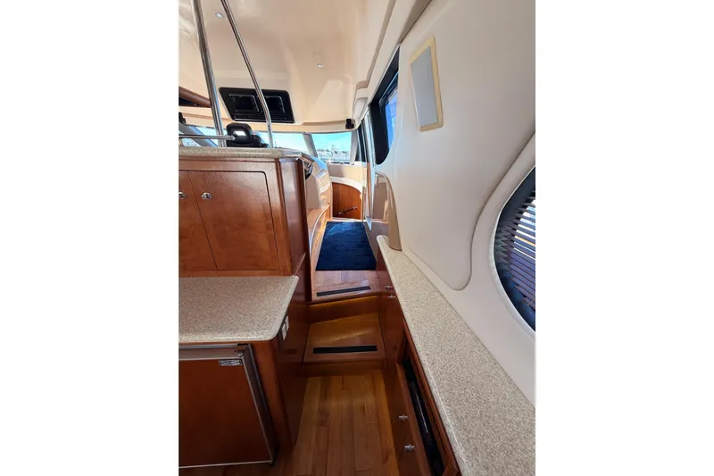 Le Reve Yacht Photos Pics Interior of 1999 Carver 530 Voyager Pilothouse with wood cabinetry and blue carpet.