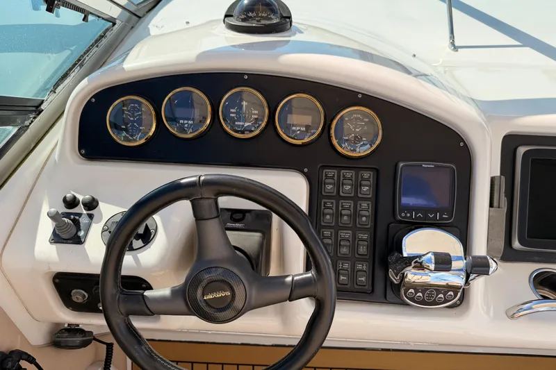 Le Reve Yacht Photos Pics Control panel of a 1999 Carver 530 Voyager Pilothouse yacht with steering wheel and gauges.