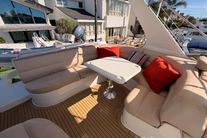 Le Reve Yacht Photos Pics Luxurious seating area on 1999 Carver 530 Voyager Pilothouse with red cushions and table.