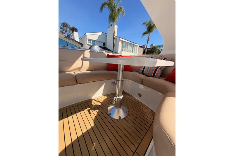 Le Reve Yacht Photos Pics 1999 Carver 530 Voyager Pilothouse interior with cushioned seating and table, featuring striped pillows.