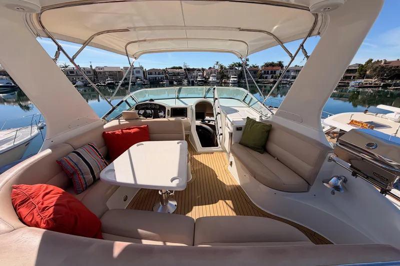 Le Reve Yacht Photos Pics Luxurious 1999 Carver 530 Voyager Pilothouse yacht interior with plush seating and scenic marina view.