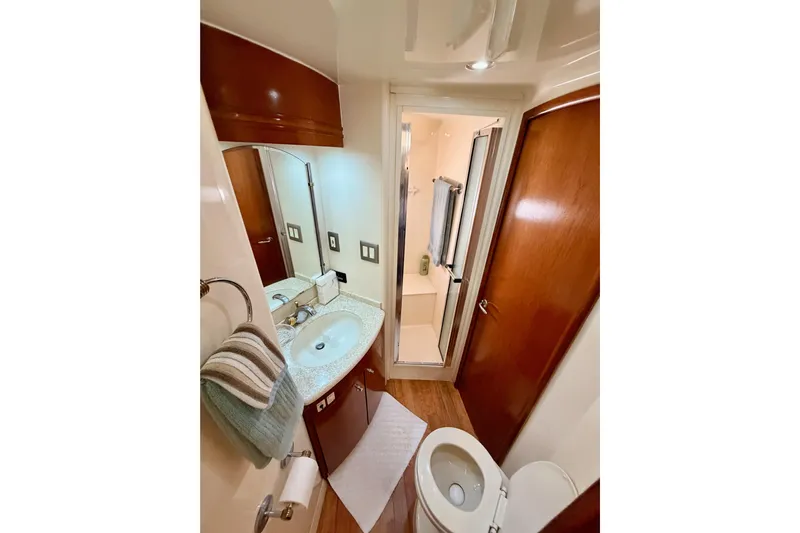Le Reve Yacht Photos Pics Bathroom interior of 1999 Carver 530 Voyager Pilothouse yacht, featuring sink, toilet, and shower.