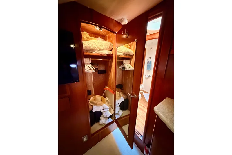 Le Reve Yacht Photos Pics Interior of 1999 Carver 530 Voyager Pilothouse showing a wooden closet with clothes and accessories.