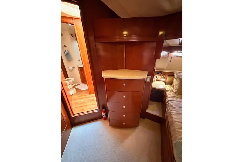 Le Reve Yacht Photos Pics Interior of 1999 Carver 530 Voyager Pilothouse with wood cabinetry and adjacent bathroom.