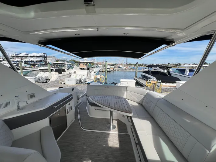 Touch Of Grey Yacht Photos Pics 2022 Sea Ray Sundancer 320 OB interior with seating and table, docked at marina.