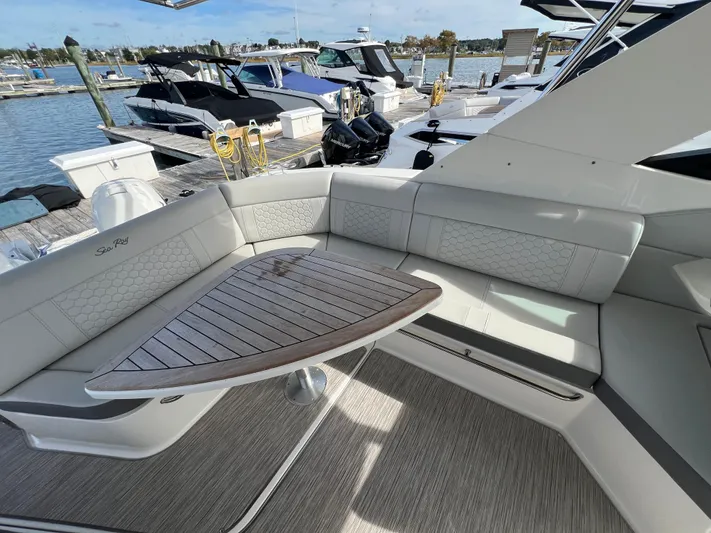 Touch Of Grey Yacht Photos Pics 2022 Sea Ray Sundancer 320 OB yacht interior with elegant seating and wooden table at marina.