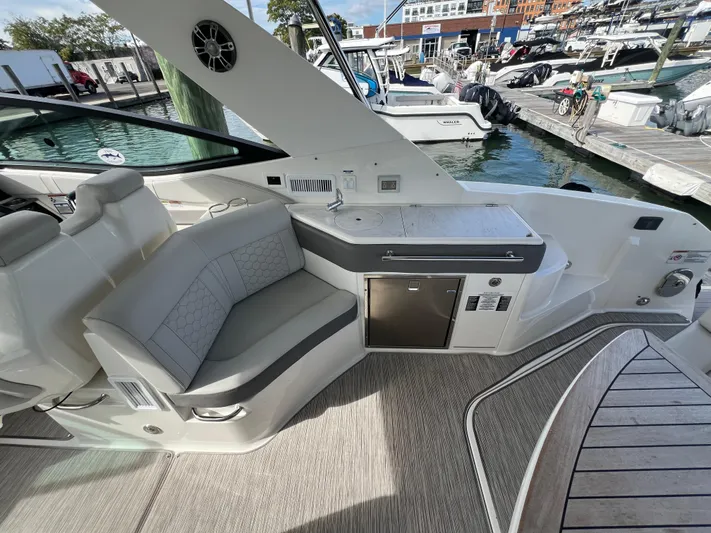 Touch Of Grey Yacht Photos Pics 2022 Sea Ray Sundancer 320 OB interior with seating and kitchenette at marina.