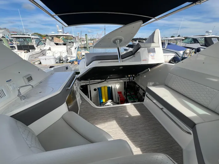 Touch Of Grey Yacht Photos Pics 2022 Sea Ray Sundancer 320 OB interior with open storage, seating, and marina view.