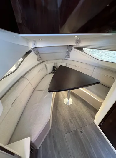 Touch Of Grey Yacht Photos Pics Interior of 2022 Sea Ray Sundancer 320 OB with modern seating and triangular table.