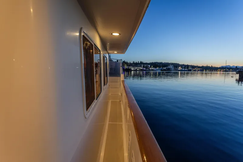 Basecamp Yacht Photos Pics Side view of 2003 Selene 47 yacht at sunset, overlooking calm waters and distant shoreline.
