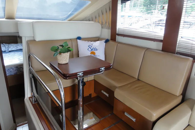  Yacht Photos Pics Interior of 2007 Sea Ray 36 Sedan Bridge with beige seating and wooden table.