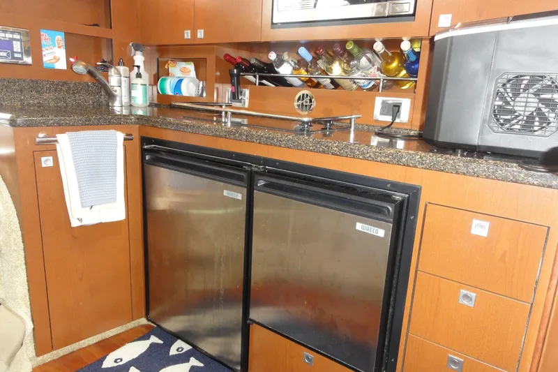  Yacht Photos Pics 2007 Sea Ray 36 Sedan Bridge kitchen with stainless steel appliances and wooden cabinetry.