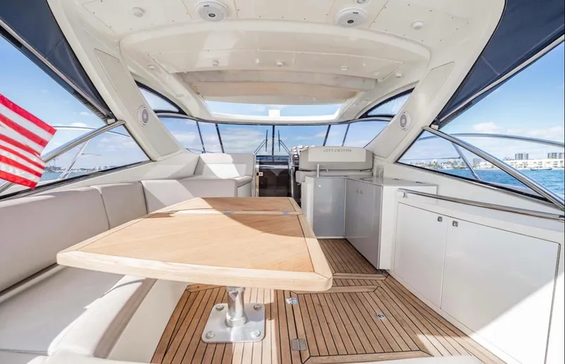 Parea Yacht Photos Pics Interior of 2011 Azimut Atlantis 40 yacht with wooden table and seating area.