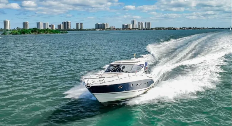 Parea Yacht Photos Pics Azimut Atlantis 40 yacht cruising on open water, city skyline in background, 2011 model.