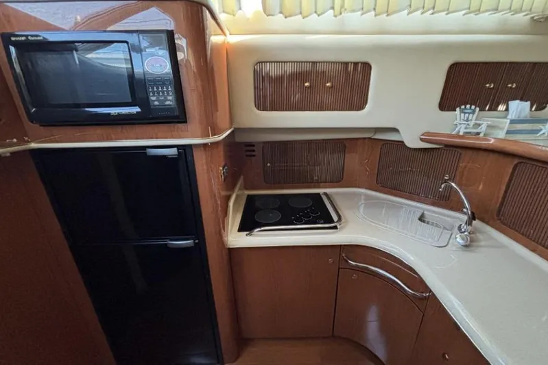 Gazoo Yacht Photos Pics 2001 Sea Ray 400 Sedan Bridge yacht kitchen with microwave, stove, and sink.