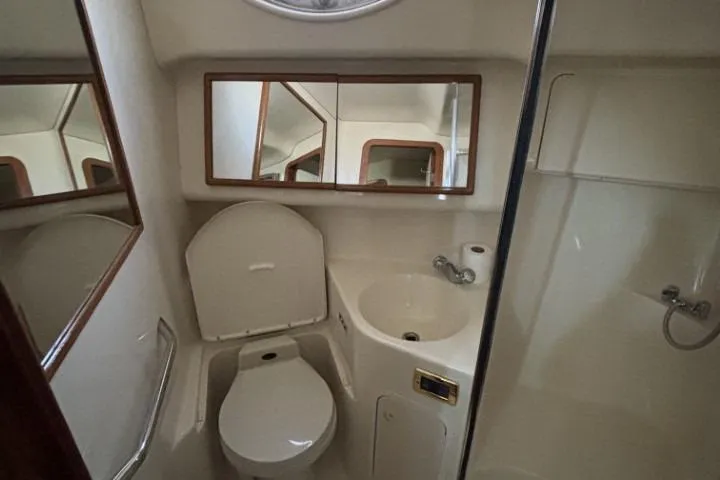 Gazoo Yacht Photos Pics Bathroom interior of 2001 Sea Ray 400 Sedan Bridge yacht, featuring toilet, sink, and mirror.